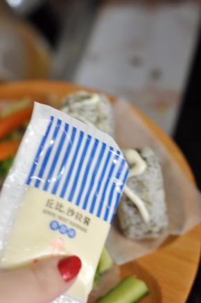 将饭团摆在盘中，顶部挤上沙拉酱。