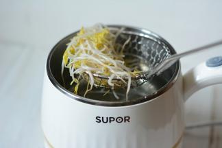 小煮锅中加入适量的水煮沸，将洗干净的豆芽放入烫上1-2分钟捞出装盘。