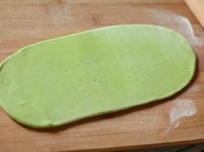 将面团朝四周擀开，尽量擀成很薄的面片。用快刀切成均匀的面条。