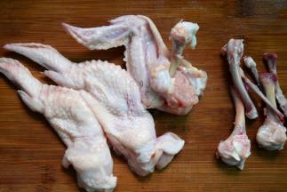 用剪刀把关节处剪断，直接用手把鸡皮翻过来往下褪，用手把骨头掰断，将翅根骨和翅中骨去除