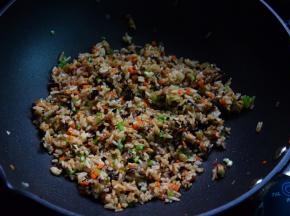 加入米饭炒散，调入盐和酱油，再加葱末炒匀