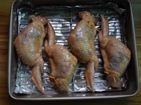 用牙签将鸡翅口别上，把鸡翅刷一遍腌制的酱汁，放在烤网上，腌制10分钟
