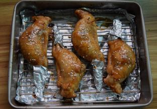 将鸡翅拿出，再把剩余的酱汁刷在鸡翅上，喜欢芝麻也可以撒点，用锡纸将翅尖包住以防烤焦，再放入烤箱烤10分钟