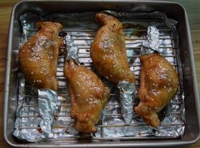 将鸡翅拿出，再把剩余的酱汁刷在鸡翅上，喜欢芝麻也可以撒点，用锡纸将翅尖包住以防烤焦，再放入烤箱烤10分钟