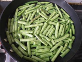水烧开后倒入四季豆，不盖锅盖。