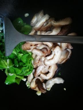 青椒炒变色后放入花菇片