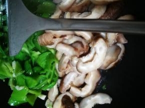 青椒炒变色后放入花菇片