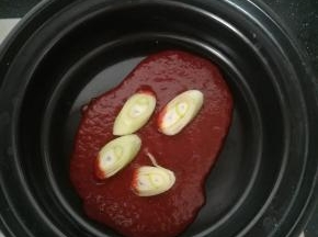 砂锅放油，加入火锅底料和大葱炒香。