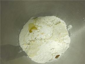 将主料中的面粉加香草精、鸡蛋、盐和剩余的糖（除黄油外）混合，并倒入酵母牛奶液搅拌成团