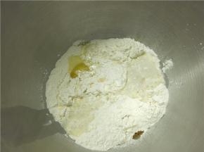 将主料中的面粉加香草精、鸡蛋、盐和剩余的糖（除黄油外）混合，并倒入酵母牛奶液搅拌成团