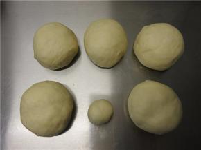 将面团按照模具分成两个，每个留出15克，其余分成5等分，滚圆盖保鲜膜松弛10分钟