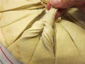 将三角的头部拉起向内弯曲穿过割口缝隙并拉直