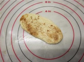 分出的15克小面团，擀成长条形，刷油撒糖撒肉桂粉