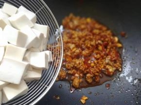 加入焯水后的豆腐翻炒一下，稍微炒一下，否则易碎噢…