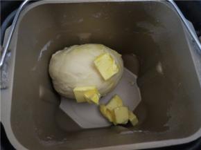 放入软化的黄油再次起动一个颌面程序直到面团光滑的扩展阶段能够拉出较薄的膜