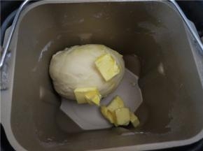 放入软化的黄油再次起动一个颌面程序直到面团光滑的扩展阶段能够拉出较薄的膜