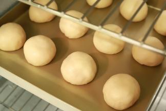 面团取出轻压排气，平均分成12份搓圆，静置20分钟。