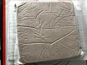 倒扣在铺了油纸的烤网上，底下的油纸揭掉，再盖在蛋糕体上，以免蛋糕表皮干掉。