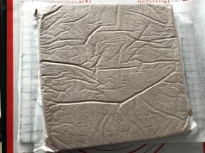 倒扣在铺了油纸的烤网上，底下的油纸揭掉，再盖在蛋糕体上，以免蛋糕表皮干掉。