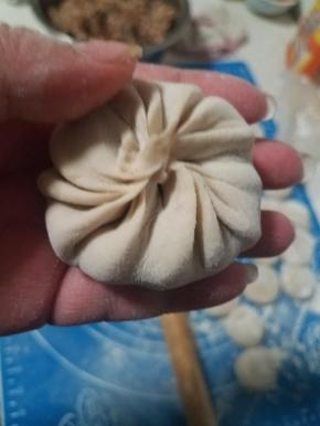 顺着一个方向捏褶皱，最后收口，变成一个圆形的包子就可以了。