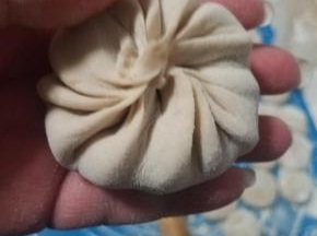顺着一个方向捏褶皱，最后收口，变成一个圆形的包子就可以了。