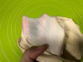 启动厨师机2档将面粉揉成团，然后换到4档继续揉面，直到检查面团能够拉出薄膜即可