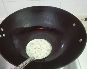 中火烧热锅，涂抹少许油，放一大勺鸡蛋面糊下锅