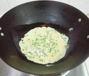 慢慢转动锅，使面糊均匀沾着锅底煎