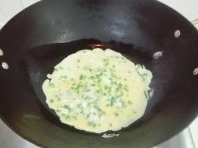 慢慢转动锅，使面糊均匀沾着锅底煎