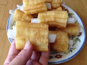 用一只筷子掏空油条的内部，把藕条穿入油条正中