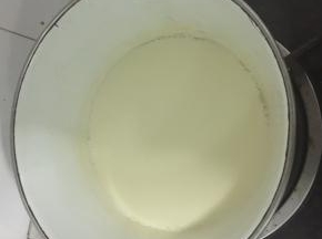 小火煮豆浆，到锅边上开始油小泡泡，然后慢慢的倒入到蛋黄混合物里面，不停的搅拌。