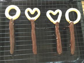 烘烤后的仙女棒饼干垂直棒均匀的抹上融化后的黑巧克
