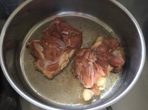 将腌制好的鸡腿肉趁油还未烧热放入锅中，鸡皮朝下放入（鸡腿放入锅中前最好用厨房纸将鸡腿上的水分吸干，避免锅中油遇水溅出）