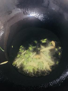 锅内放入适量的油烧至五成热时放入葱姜爆香