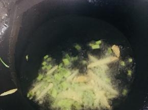 锅内放入适量的油烧至五成热时放入葱姜爆香