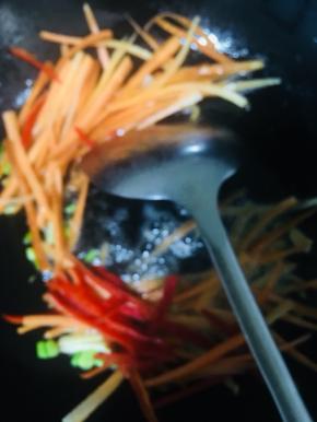 放入胡萝卜和红椒翻炒片刻