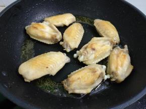 热锅倒入适量菜籽油，烧八成热。放入鸡翅煎至两面金黄。
