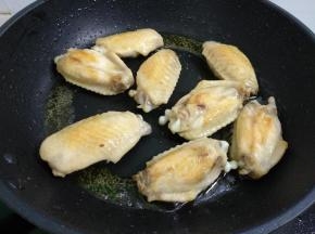 热锅倒入适量菜籽油，烧八成热。放入鸡翅煎至两面金黄。