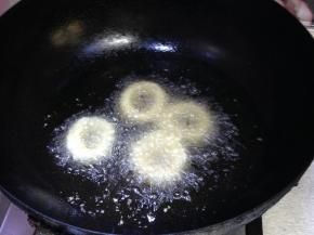 下入鱿鱼圈，炸至两面金黄即可出锅