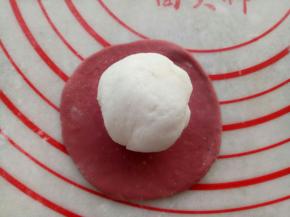 取一块红色面团擀成圆形包上一块白色面团。