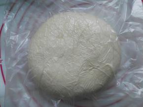 放入保鲜袋内，用擀面杖把面团擀成一个方形的厚面片，大小大概是20CM的长宽度，放入冰箱里冷冻1小时左右；