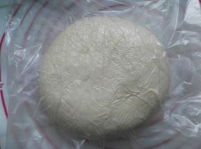放入保鲜袋内，用擀面杖把面团擀成一个方形的厚面片，大小大概是20CM的长宽度，放入冰箱里冷冻1小时左右；