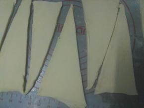 开始塑形，将面片稍压扁，用擀面杖擀成长方形，力度要轻柔，擀成大约是0.3CM厚度的面片，大概长度是50CM，宽度是20CM.再用锋利的刀把面片长边10厘米长度做一个标志，再分成高度为20cm的等边三角形