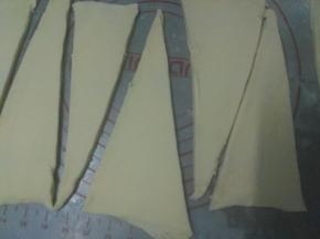 开始塑形，将面片稍压扁，用擀面杖擀成长方形，力度要轻柔，擀成大约是0.3CM厚度的面片，大概长度是50CM，宽度是20CM.再用锋利的刀把面片长边10厘米长度做一个标志，再分成高度为20cm的等边三角形
