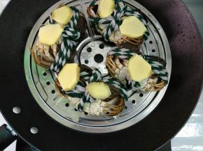 锅里倒入适量清水，大闸蟹腹部朝上背部朝下摆入蒸锅，放上姜片。选“蒸煮”功能将其煮开上汽后再蒸15分钟左右（具体时间根据蟹大小调整）
