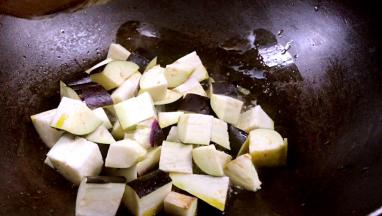 锅烧热油，加少许盐炒匀，倒入茄丁，中火煎炒