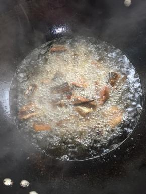 锅烧热倒入适量的油烧至七成热，放入腌制好的黄鳝段中火慢慢的炸！