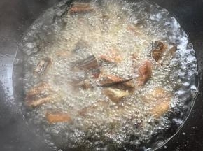 锅烧热倒入适量的油烧至七成热，放入腌制好的黄鳝段中火慢慢的炸！
