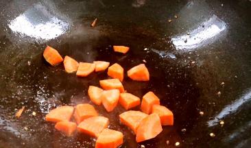 再将胡萝卜丁，放入锅中炒断生后盛出备用