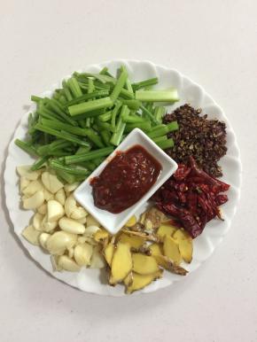 蒜瓣3个去皮稍微拍一下即可，生姜一块洗净切片，芹菜3颗去掉芹菜叶洗净切成段儿，干辣椒10克，花椒10克，郫县豆瓣酱1勺备用！